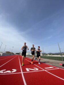 Gijs, Tony, and Max standing on the Inca running track during the Running Mallorca Training Camp 2024, preparing for a training session.