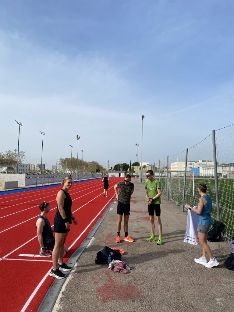 Runners pushing through an intense track session at the Inca running track during the Running Mallorca Training Camp 2024.